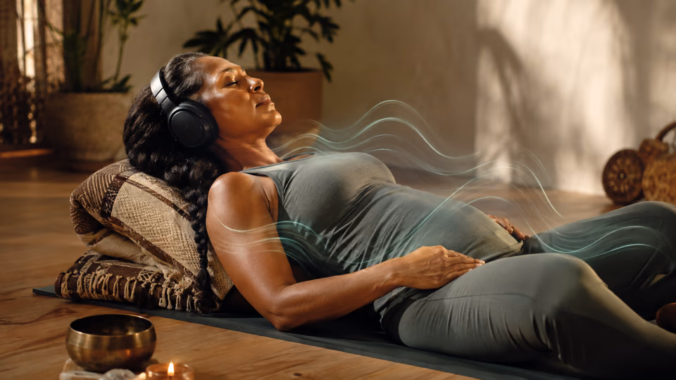 Woman resting with headphones as calming sound helps the body soften