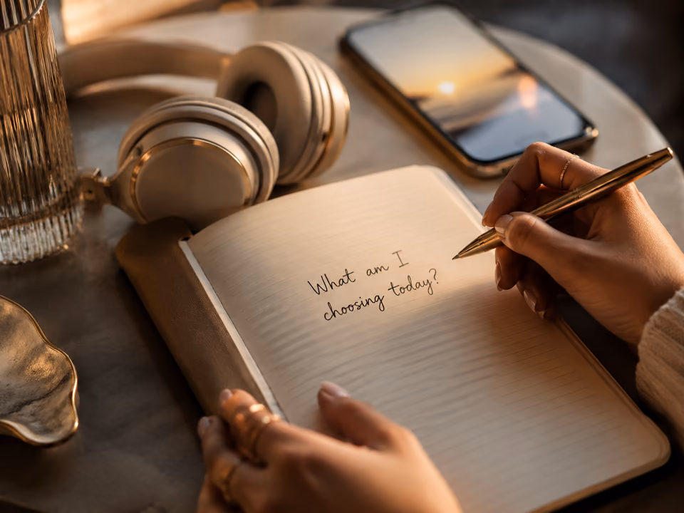 Morning manifestation journal open to the prompt What am I choosing today beside headphones and a phone